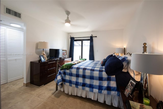 tiled bedroom featuring ceiling fan and a closet