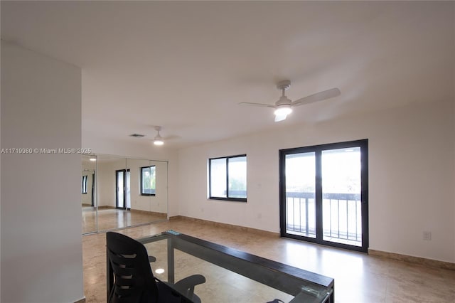 exercise area with plenty of natural light and ceiling fan