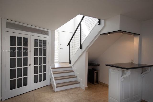 stairs with tile patterned floors and french doors