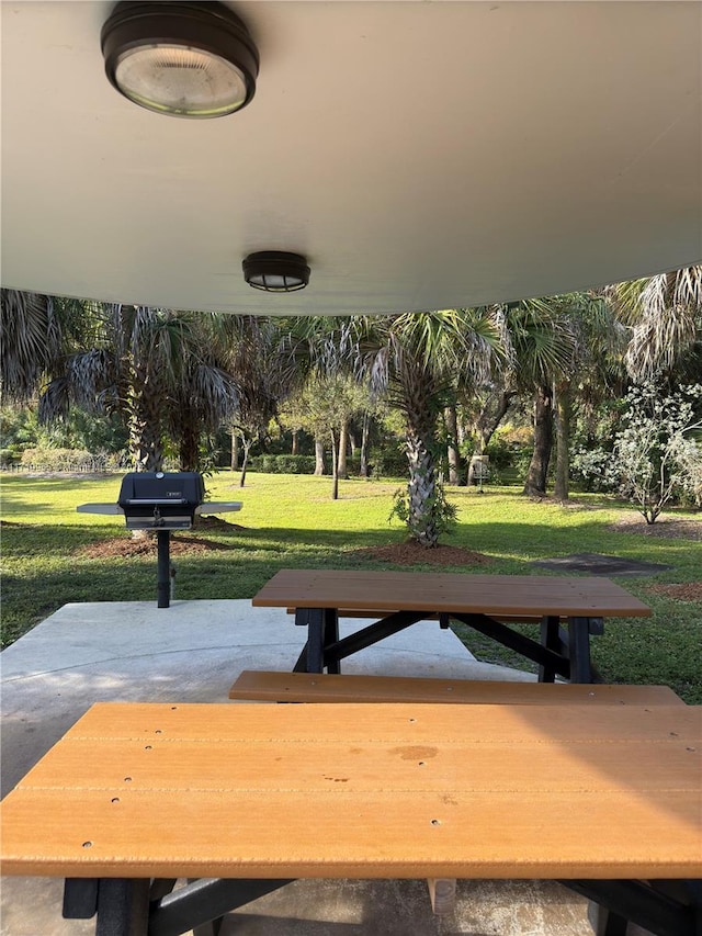 view of property's community with a patio area and a lawn