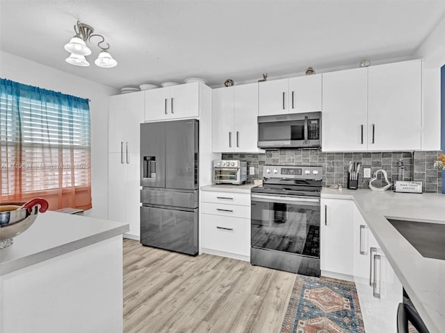 kitchen featuring light countertops, appliances with stainless steel finishes, and backsplash