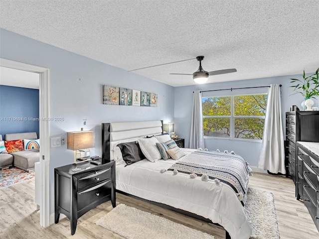 bedroom with a textured ceiling, ceiling fan, and light wood-style floors