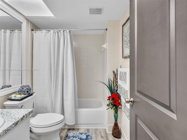 bathroom with visible vents, toilet, shower / tub combo, vanity, and wood finished floors