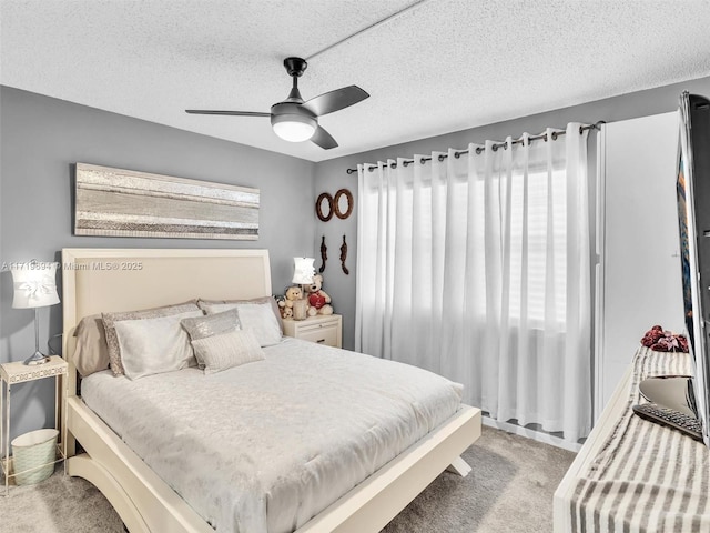 carpeted bedroom with a ceiling fan and a textured ceiling