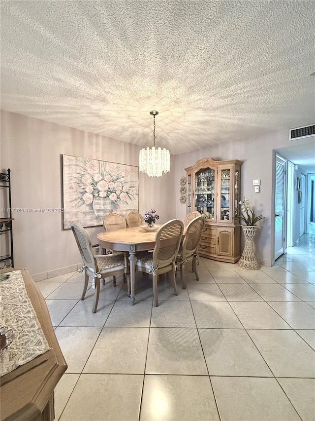 dining area featuring light tile patterned flooring and a notable chandelier