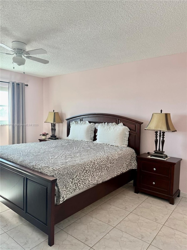 bedroom with ceiling fan and a textured ceiling