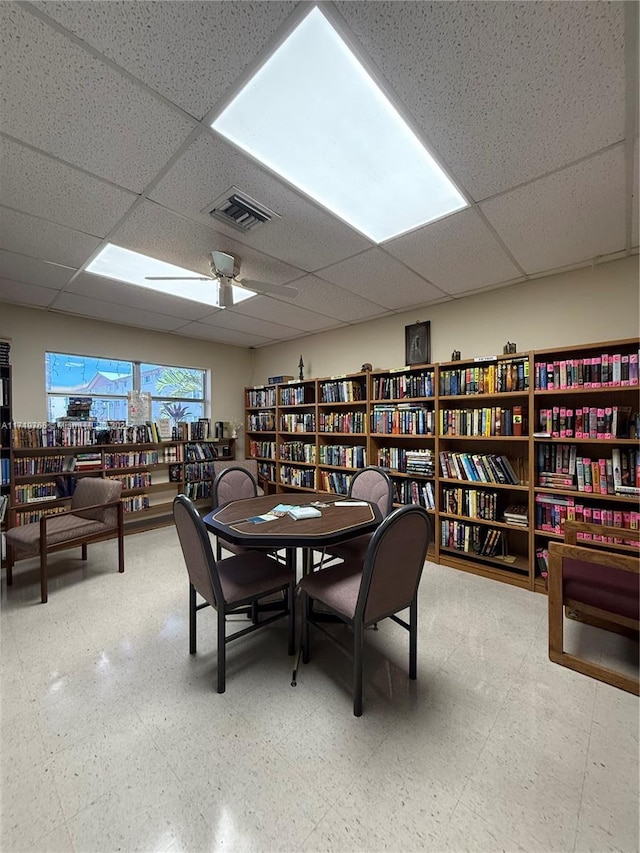 dining area with a paneled ceiling and ceiling fan