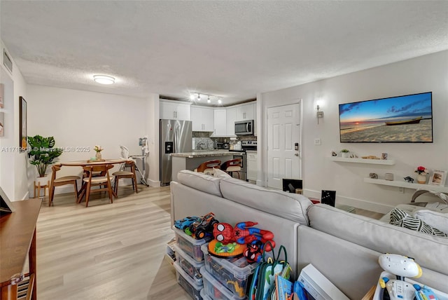 living room featuring a textured ceiling and light wood-type flooring