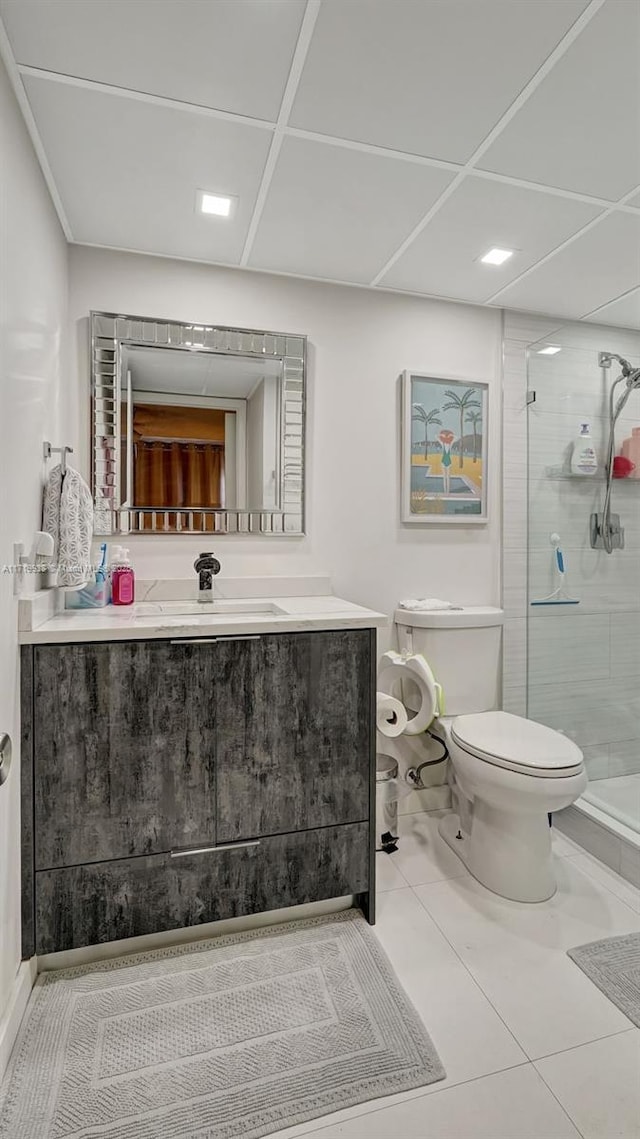 bathroom with tile patterned floors, vanity, toilet, and a shower with shower door