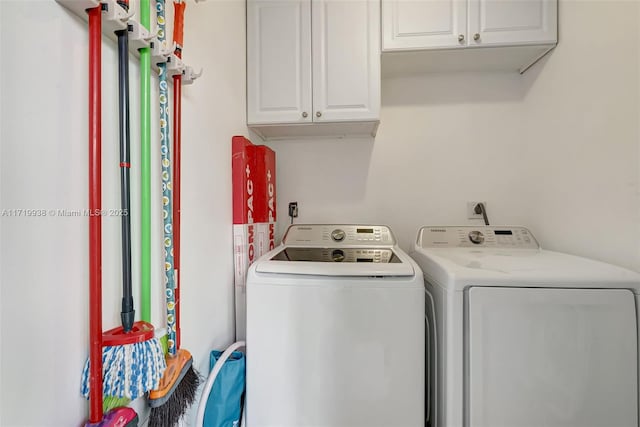 laundry area with cabinets and washing machine and clothes dryer