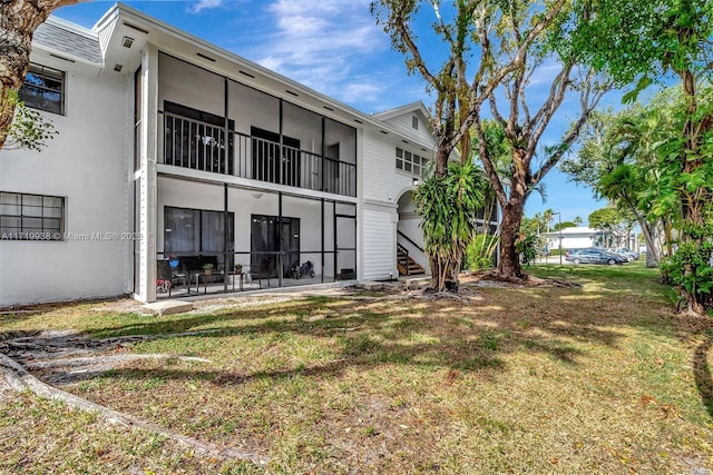 rear view of house featuring a yard