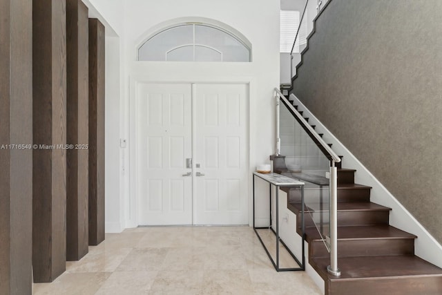 tiled foyer with a towering ceiling