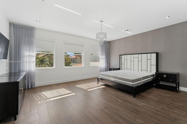 bedroom featuring a chandelier and dark wood-type flooring