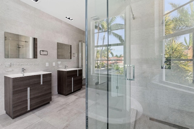 bathroom featuring tile walls, an enclosed shower, and vanity