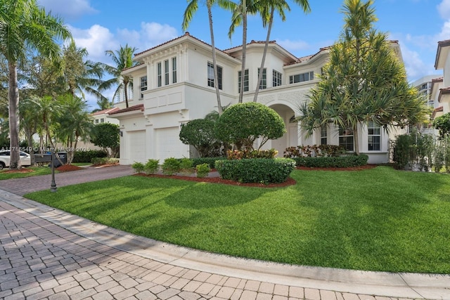 mediterranean / spanish house featuring a front yard and a garage