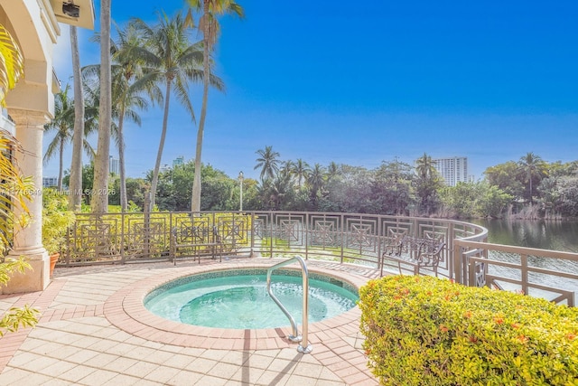 view of swimming pool featuring an in ground hot tub and a water view