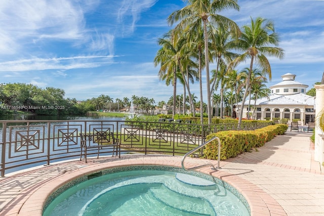 view of swimming pool with a water view and an in ground hot tub