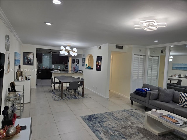 living room with crown molding, light tile patterned floors, and ceiling fan with notable chandelier