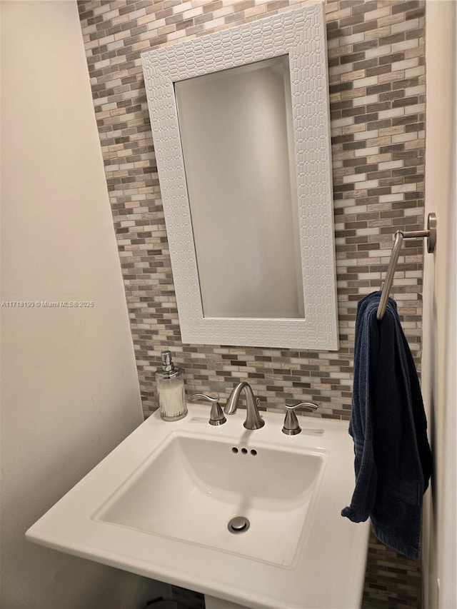 bathroom featuring backsplash and sink