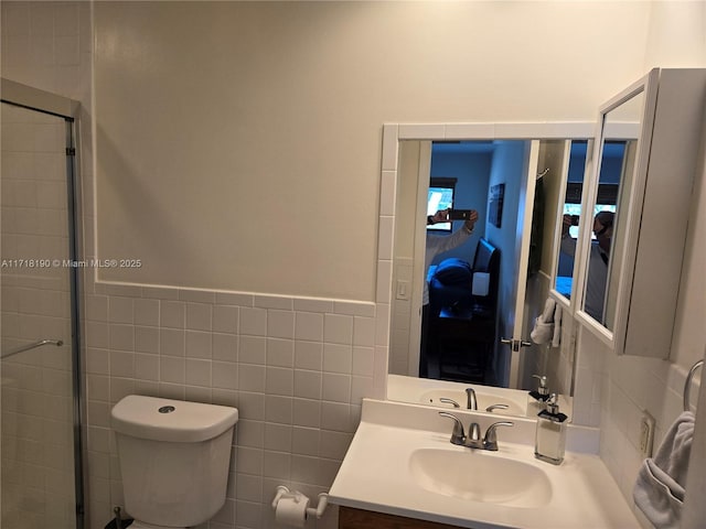 bathroom featuring an enclosed shower, vanity, toilet, and tile walls