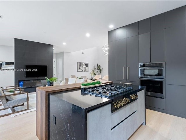 kitchen with light wood-type flooring, appliances with stainless steel finishes, and a center island