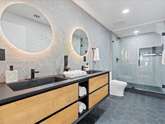 bathroom with an enclosed shower, vanity, toilet, and tile walls