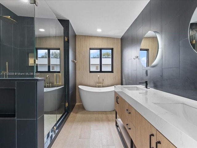 bathroom with hardwood / wood-style floors, vanity, and independent shower and bath