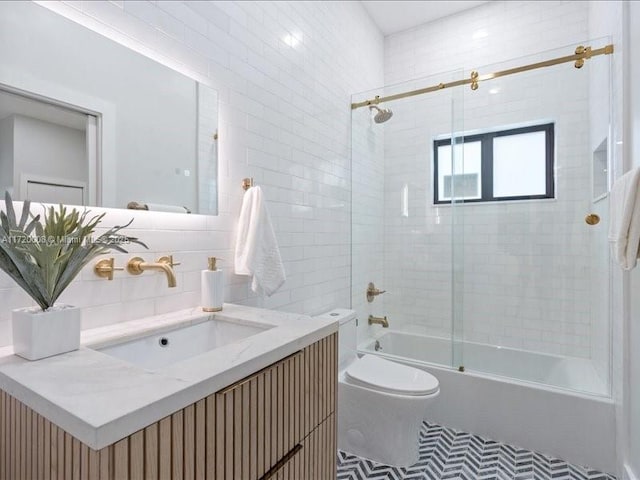 full bathroom with tasteful backsplash, combined bath / shower with glass door, toilet, vanity, and tile walls