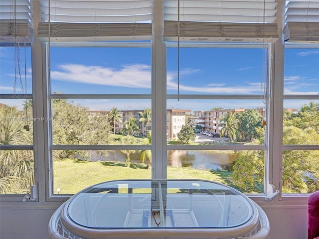 sunroom featuring a water view