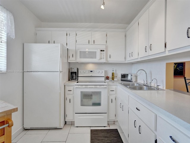 kitchen with white cabinetry, sink, light tile patterned floors, and white appliances