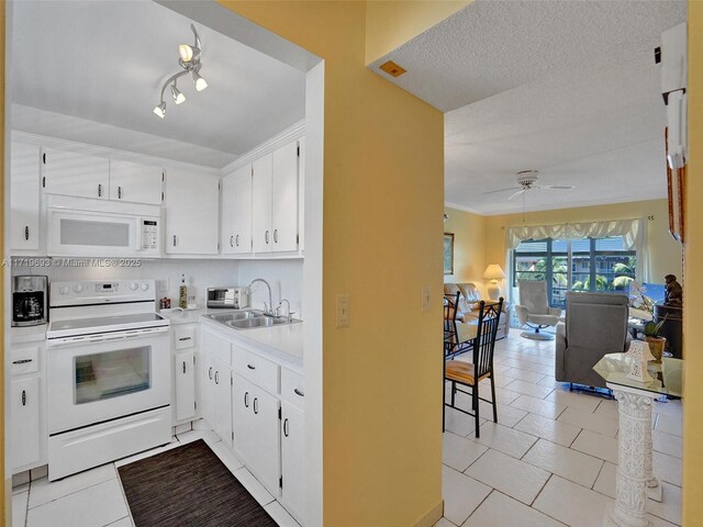 kitchen with sink, light tile patterned floors, backsplash, white appliances, and white cabinets