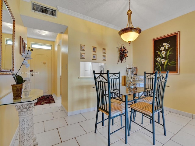 tiled dining space featuring a textured ceiling and crown molding