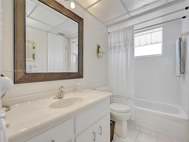 full bathroom with a drop ceiling, vanity, tile patterned flooring, toilet, and shower / tub combo