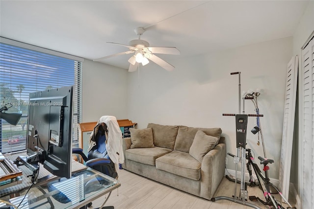 office space featuring a wall of windows, light hardwood / wood-style flooring, and ceiling fan