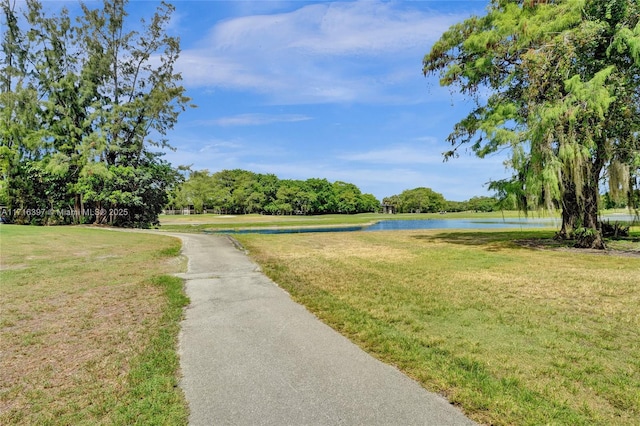 view of home's community featuring a water view and a lawn