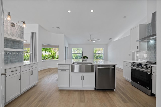 kitchen with white cabinets, wall chimney range hood, and appliances with stainless steel finishes