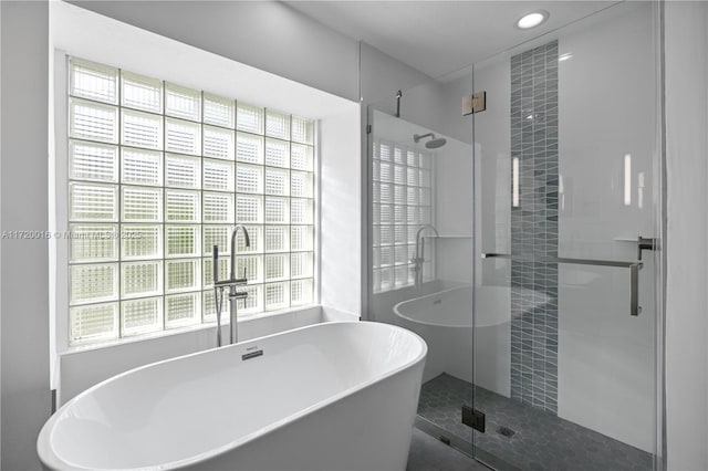 bathroom featuring a healthy amount of sunlight and shower with separate bathtub