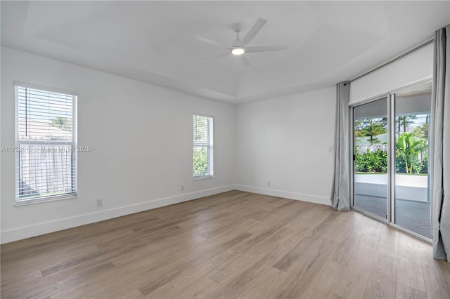 spare room with a wealth of natural light, a raised ceiling, and ceiling fan