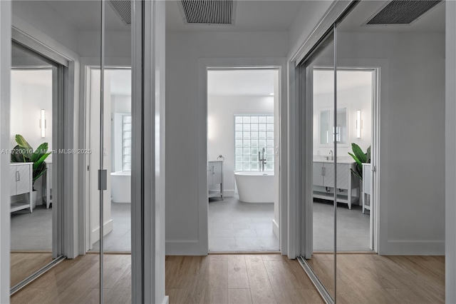 hallway featuring light hardwood / wood-style flooring and sink