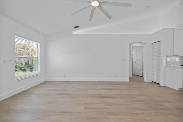 spare room featuring ceiling fan, light wood-type flooring, and vaulted ceiling