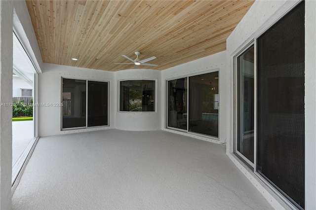 unfurnished sunroom with ceiling fan and wood ceiling