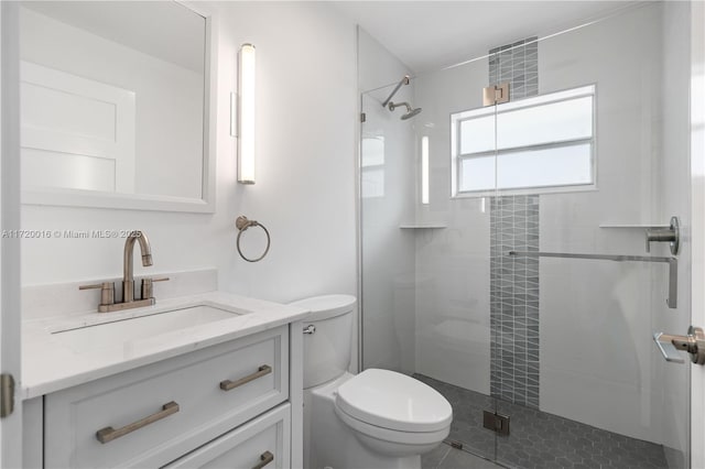 bathroom featuring vanity, toilet, and a shower with shower door