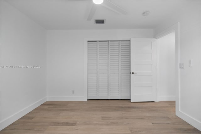 unfurnished bedroom featuring light wood-type flooring, a closet, and ceiling fan