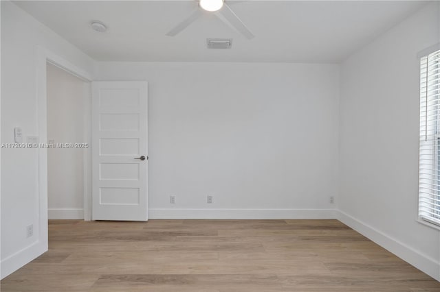 empty room featuring light hardwood / wood-style flooring, a wealth of natural light, and ceiling fan