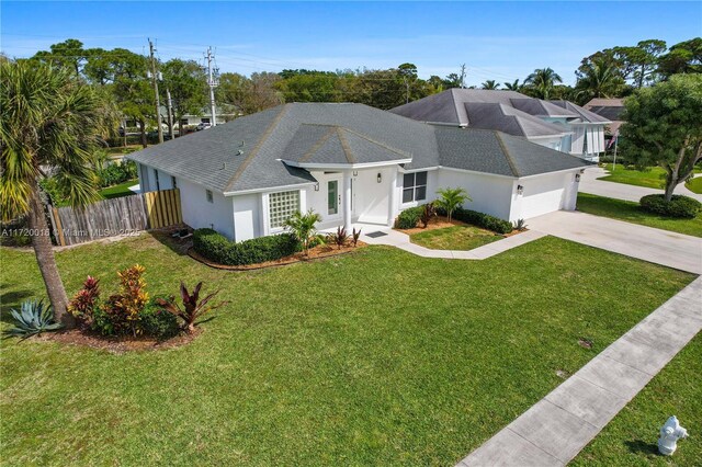 ranch-style home featuring a garage and a front lawn