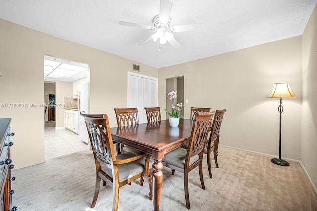 carpeted dining area featuring a textured ceiling and ceiling fan