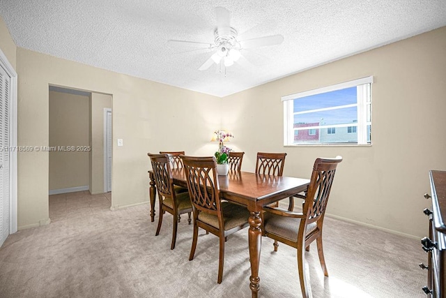 carpeted dining area with ceiling fan and a textured ceiling