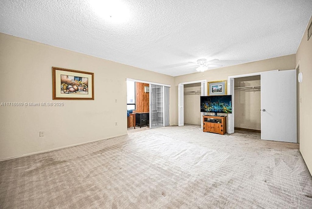 unfurnished living room with ceiling fan, light colored carpet, and a textured ceiling