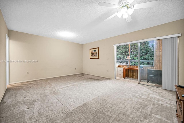 unfurnished living room featuring carpet, ceiling fan, and a textured ceiling