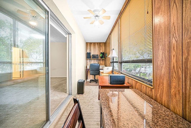 bathroom with ceiling fan and wooden walls